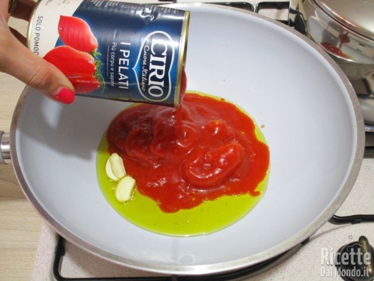 Riscaldare l'olio e unirvi i pomodori pelati